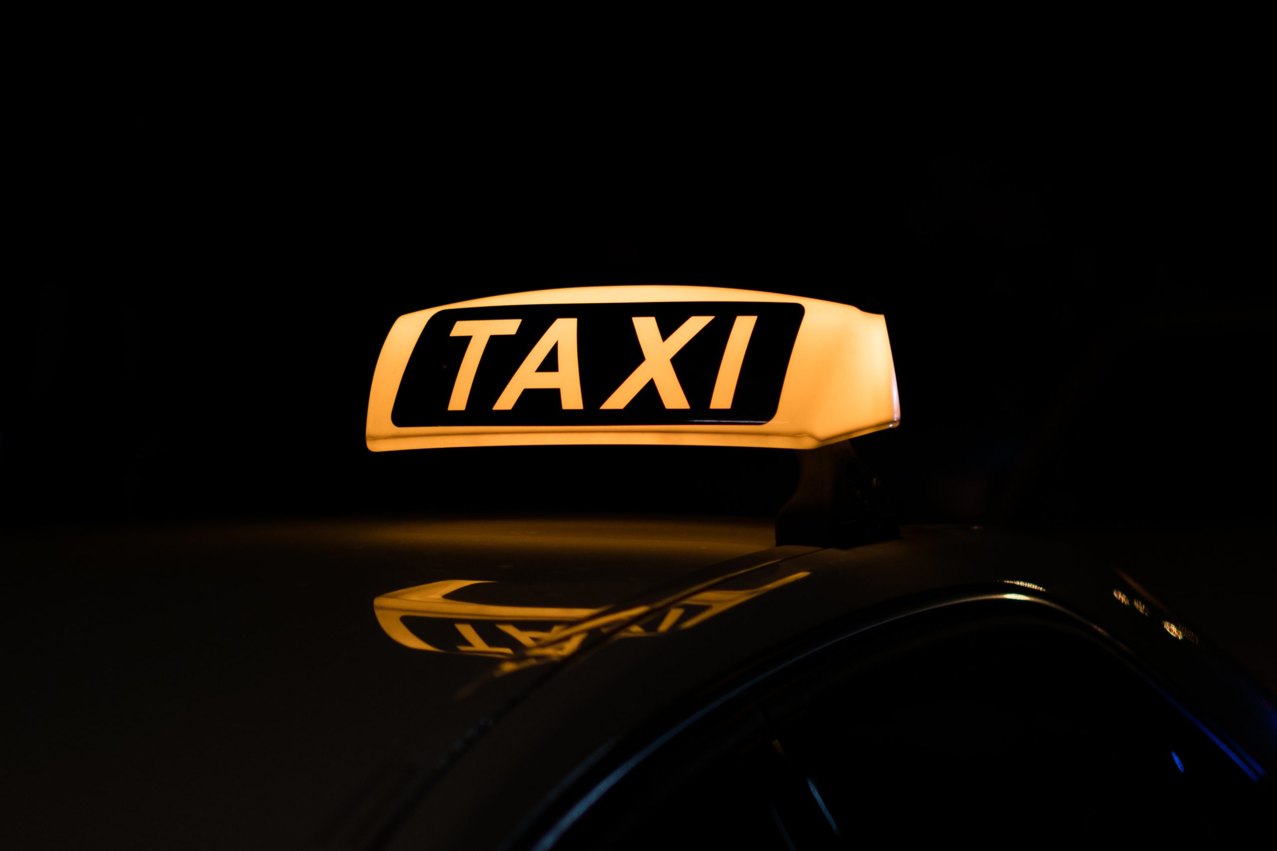 Beleuchtetes Taxischild bei Nacht